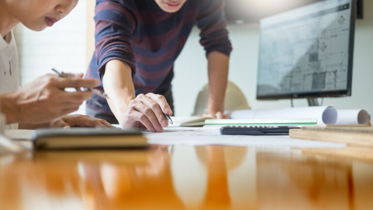 Professional Architects Working On Blueprint Discussing Construc